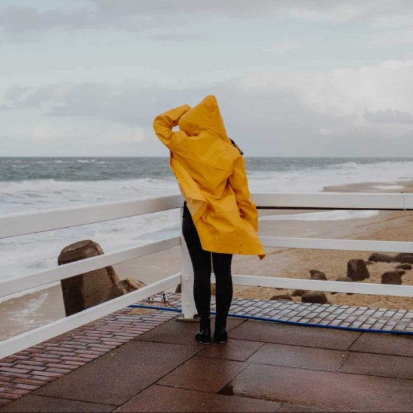 Sylt bei Regen: Gelbe Regenjacke am Strand